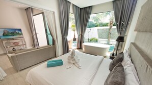 A hotel room with a bed, a desk, a TV, a bathtub, and a view of the outdoors. - Tropicana Pool Villa (Pattaya)