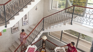 A spacious interior with a staircase, seating area, and large windows. - Alacati Villa Renk (Cesme)