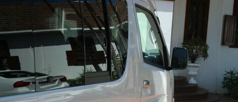 A white van parked in front of a building with a reception sign. The van has "The Estuary Hotel & Spa" and a phone number on its side.