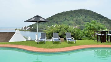 Una piscina al aire libre, tumbonas
