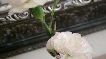 A vase with flowers on a reflective surface.