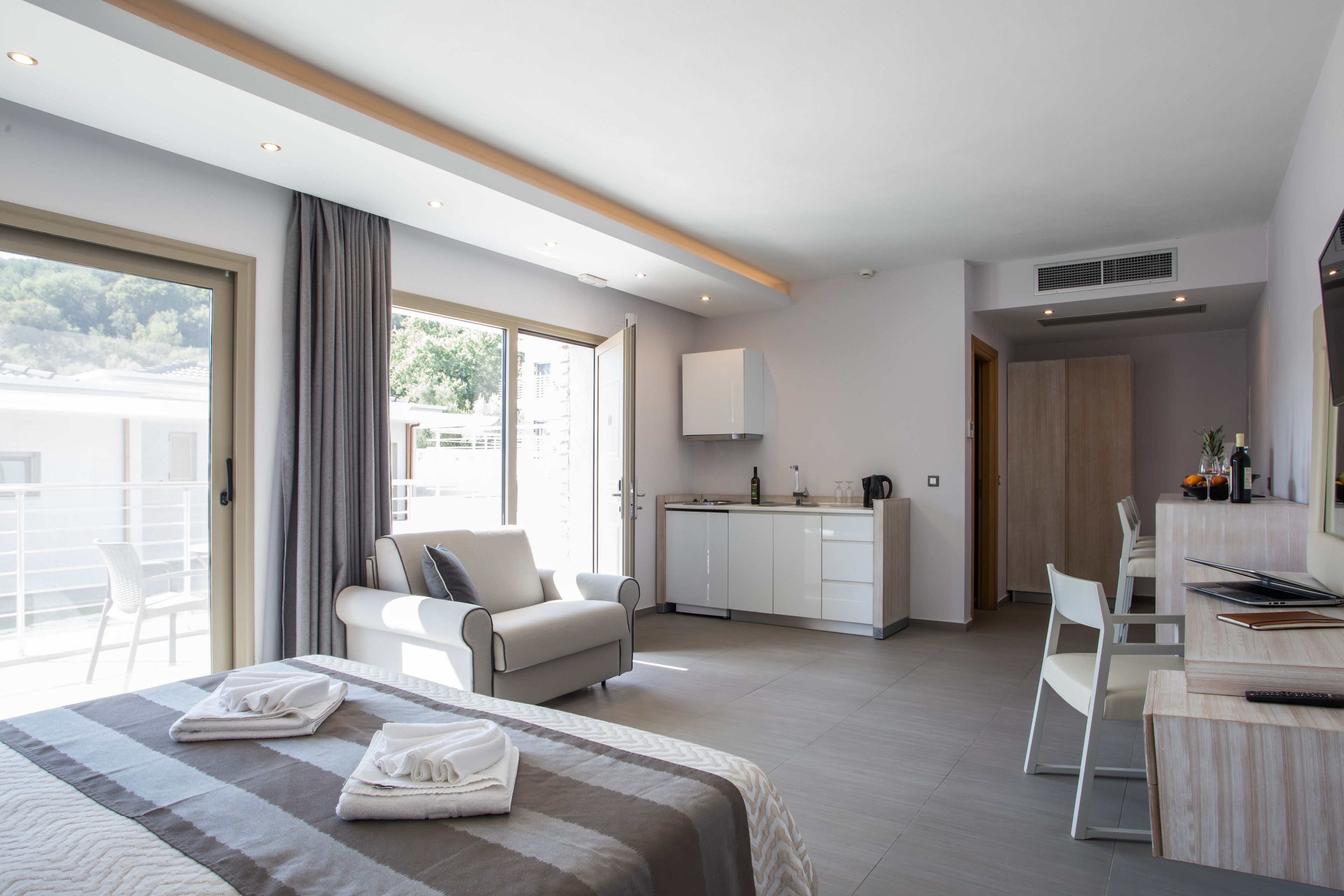 Une chambre d’hôtel moderne équipée d’un lit, d’un canapé, d’une table à manger et d’un coin cuisine.