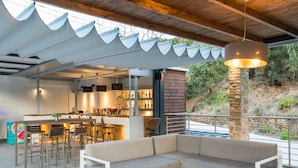 A modern outdoor seating area with a sofa, chairs, and a bar. - Aqua Oliva Resort (Igoumenitsa)