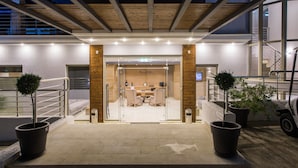 A reception area with a modern design, featuring a reception desk, seating area, and potted plants. - Aqua Oliva Resort (Igoumenitsa)