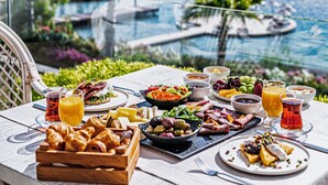 Een gedekte tafel met ontbijt en uitzicht op een jachthaven.