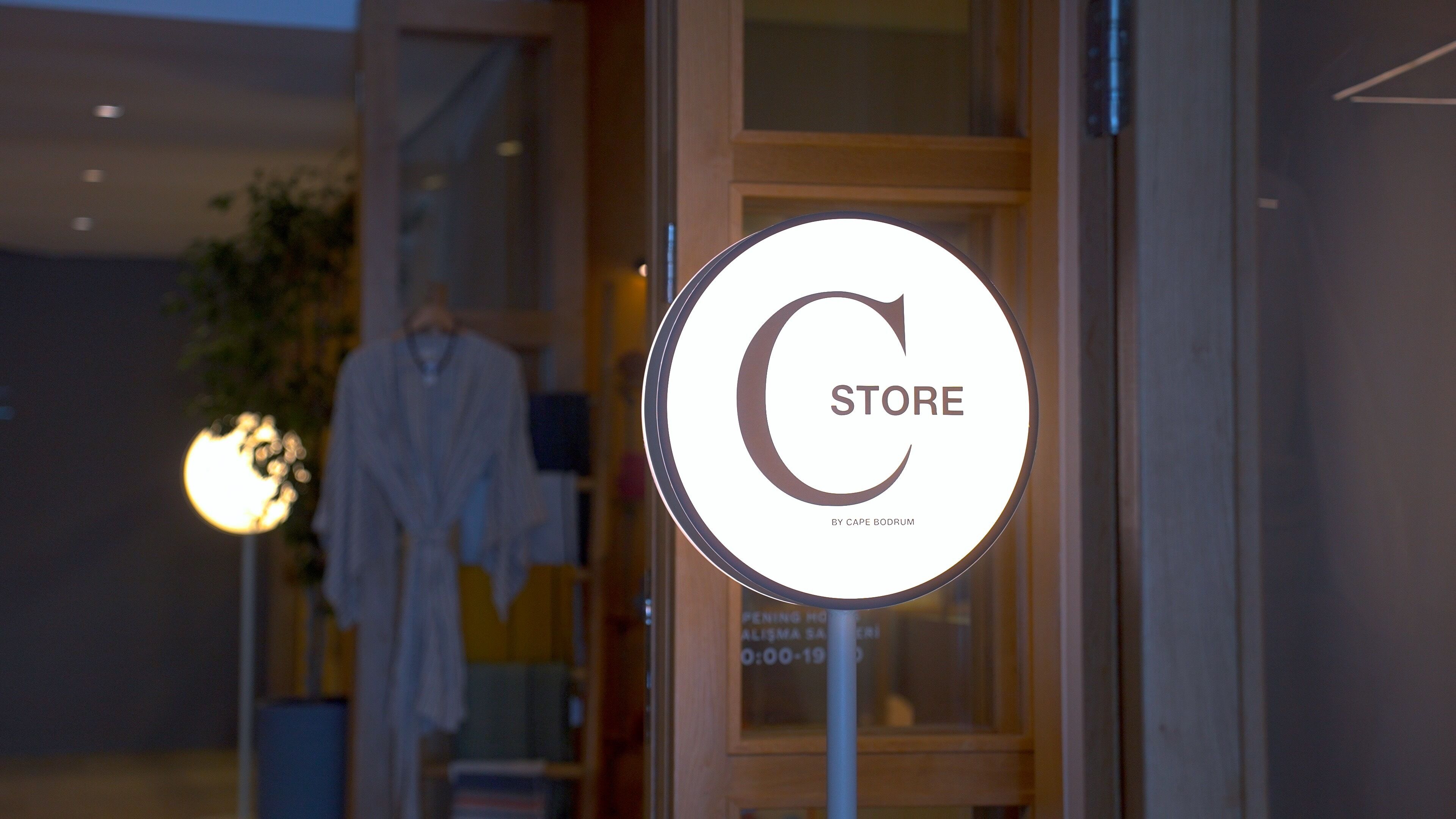 Une devanture de magasin avec une enseigne circulaire portant les mots « MAGASIN » et « BY CAPE BODIUM ».