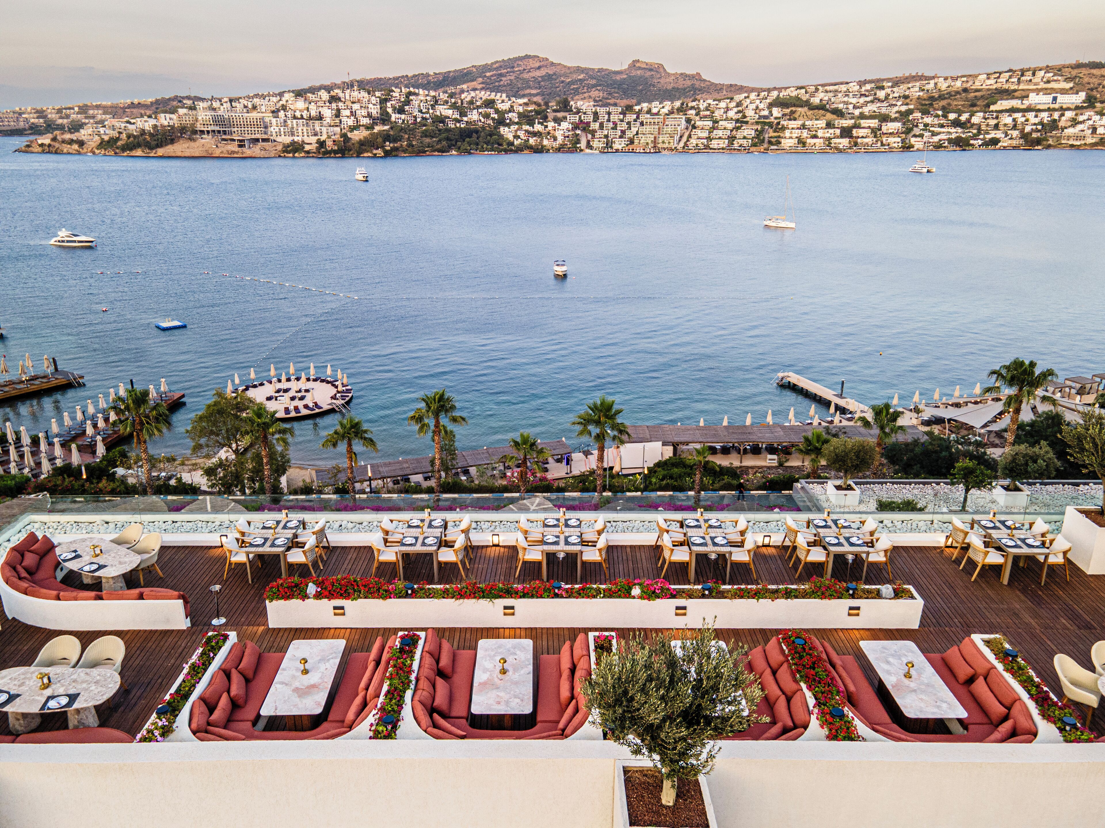 A rooftop terrace with outdoor seating and a view of the sea.