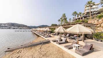 Accommodatie ligt op het strand, ligstoelen, parasols, strandlakens