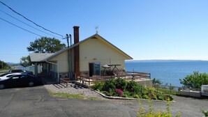 A two-story building with a balcony overlooking a body of water. - Motel Carleton sur mer (Carleton-sur-Mer)