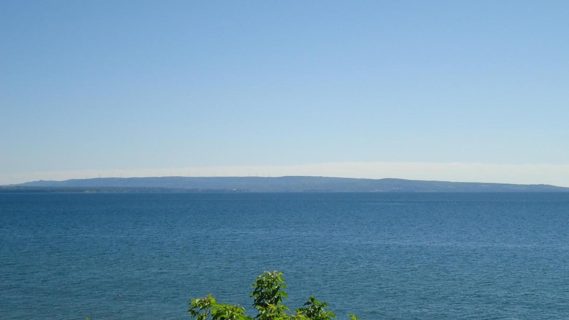 A coastal view with a clear sky and calm sea.