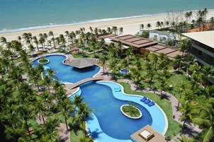 Una piscina al aire libre, sombrillas, sillones reclinables de piscina