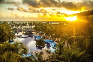 Una piscina al aire libre, sombrillas, sillones reclinables de piscina