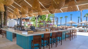A bar area with a counter, bar stools, and hanging wicker lamps. - FashionTV Luxe Resort - Luxury All Inclusive (Kemer)