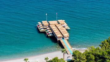 Een privéstrand, ligstoelen aan het strand, parasols, strandlakens