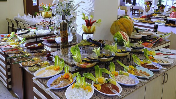 Un bufé con diversos platos y frutas frescas.