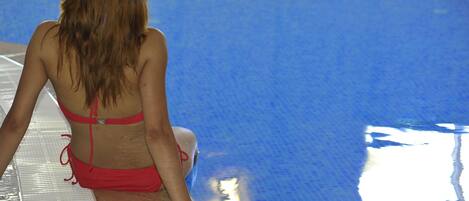 A person sitting by a poolside.