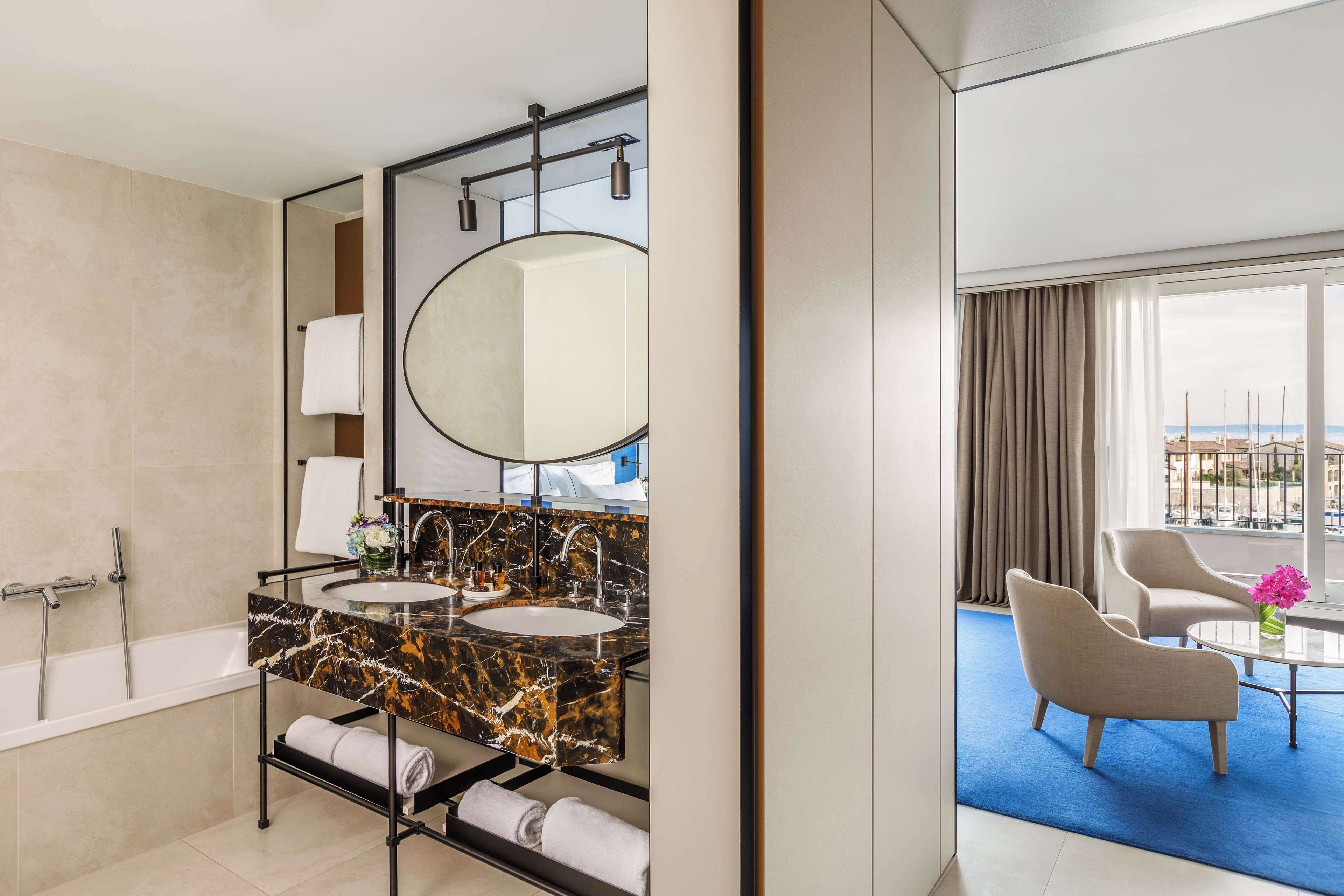Une salle de bain moderne avec une baignoire, deux lavabos et un grand miroir.