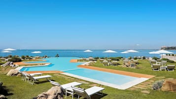 Alberca al aire libre, sombrillas en la alberca y camastros