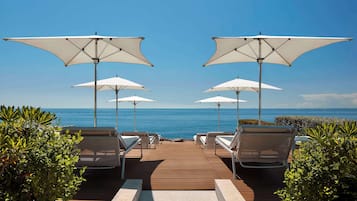 Privat strand, solstolar, parasoller och strandhanddukar