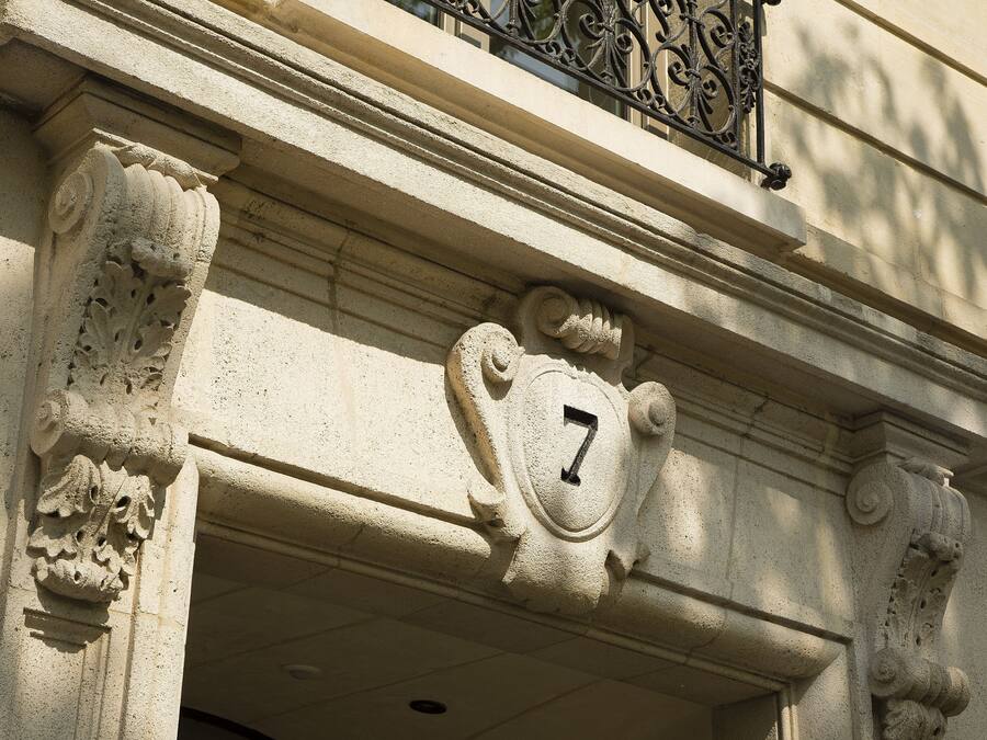 A building facade with a number '7' and ornate stone carvings.