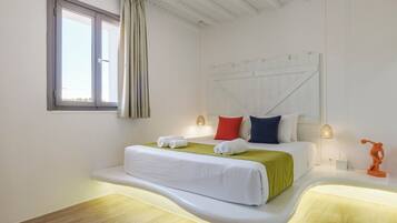 A modern bedroom with a curved bed, a window with curtains, and a unique orange sculpture.