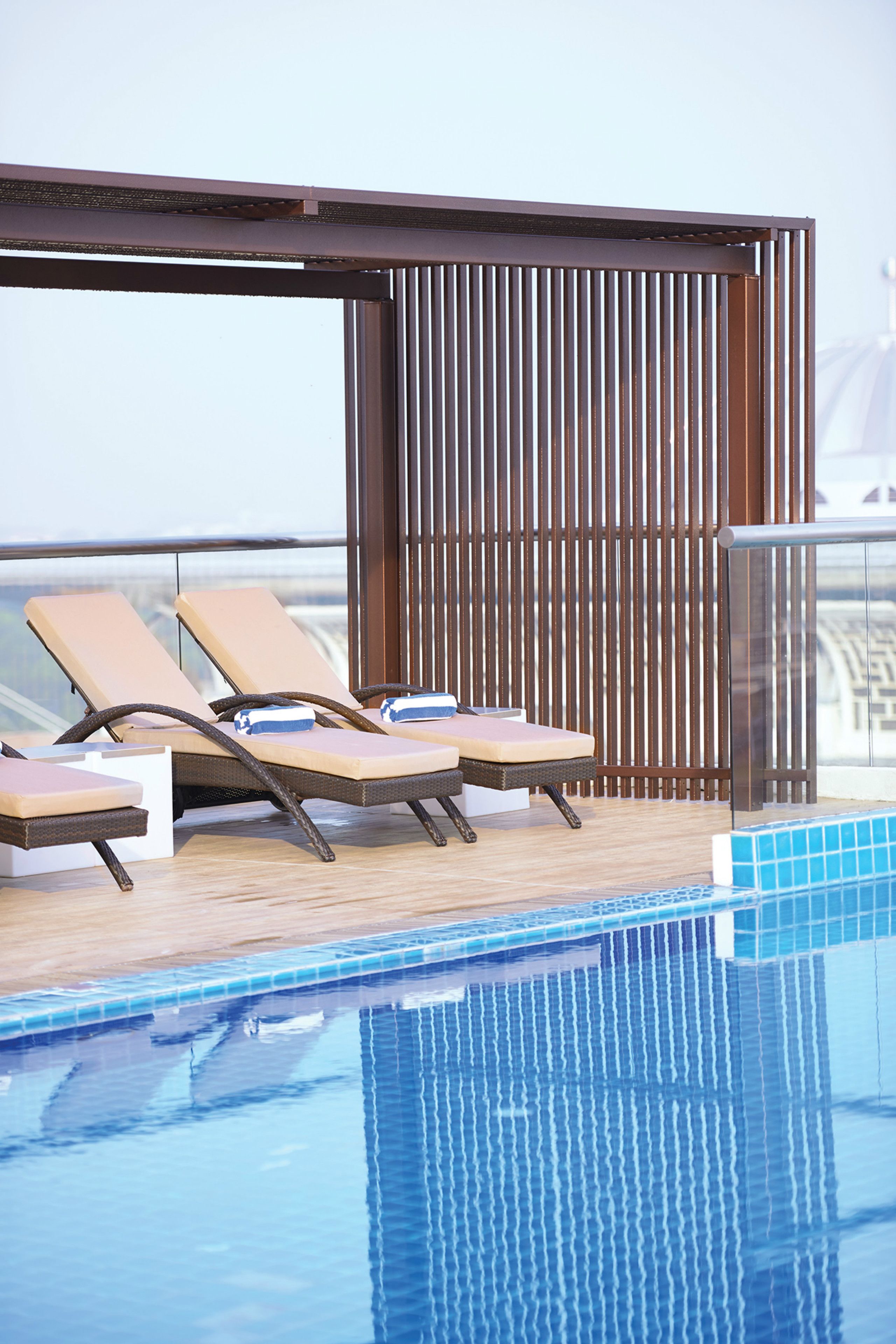 Un espace aménagé au bord de la piscine, avec des chaises longues et une terrasse en bois.