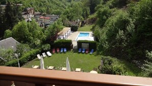 Un paisaje montañoso con una zona de piscina rodeada de abundante vegetación y edificios residenciales.
