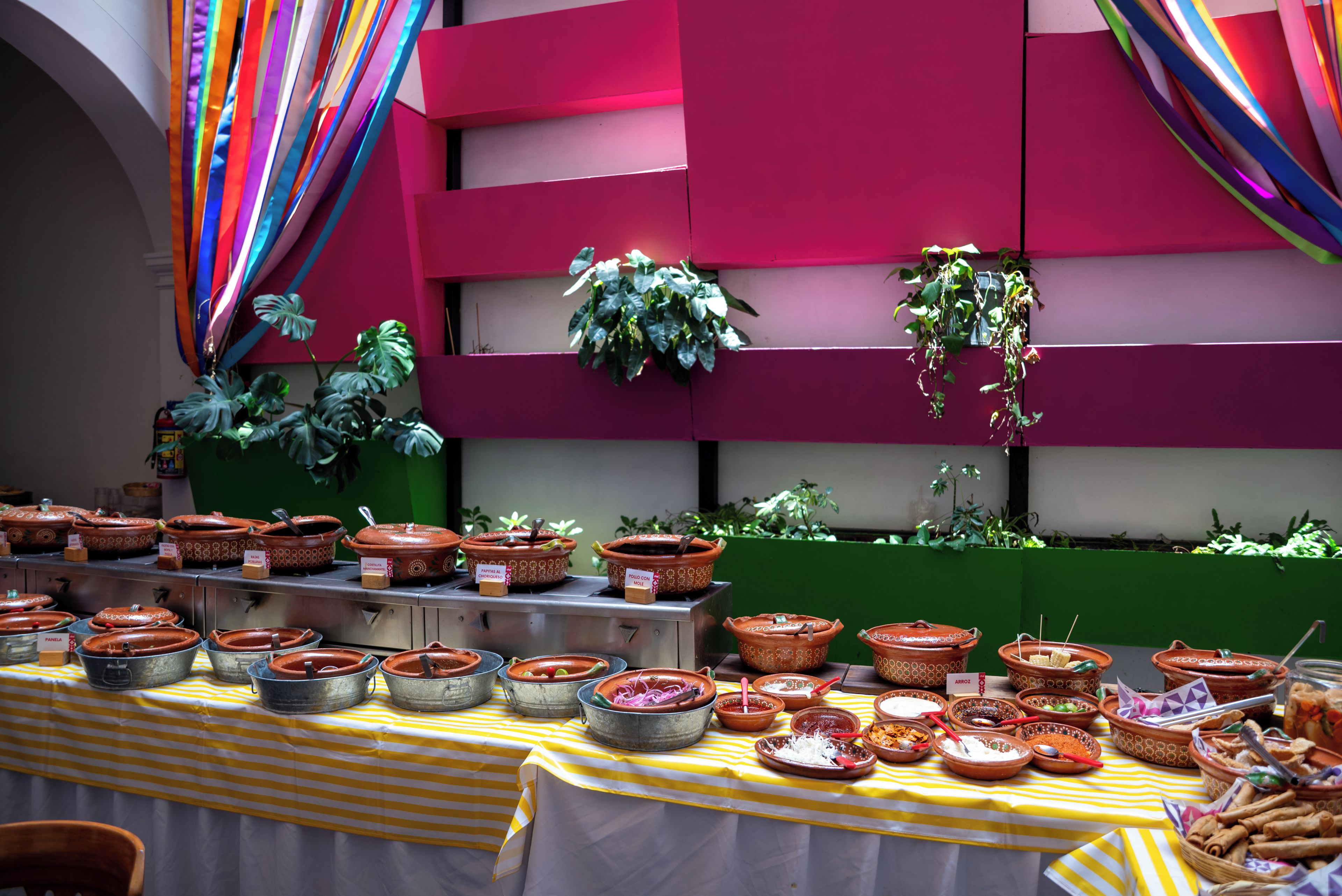 Una mesa de buffet con diversos platos y una pared colorida al fondo.
