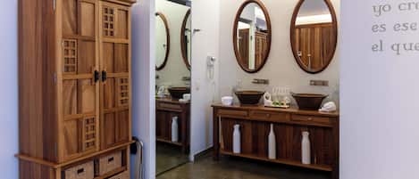 A bathroom with wooden cabinets, a sink, and two mirrors.