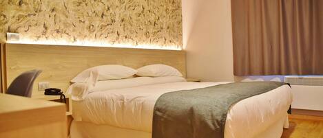 Ein Hotelzimmer mit einem Bett, einem Schreibtisch und einer Wandleuchte.
