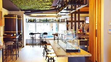 A bar area with stools, a counter, and shelves of bottles.