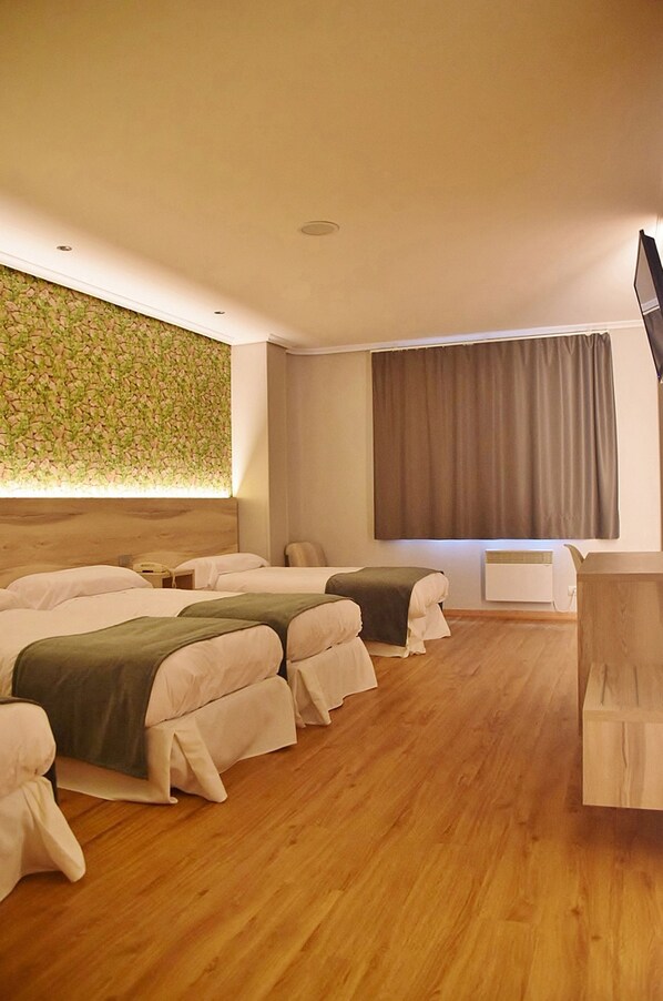 A hotel room with two beds, a wooden headboard, a flat-screen TV, a window with curtains, and a wall-mounted air conditioner. - Hospedium Hotel La Marina (Cee)