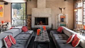 A modern living room with a fireplace, grey sofas, and red patterned cushions. - Totem, Friendly Hotel (Araches-la-Frasse)
