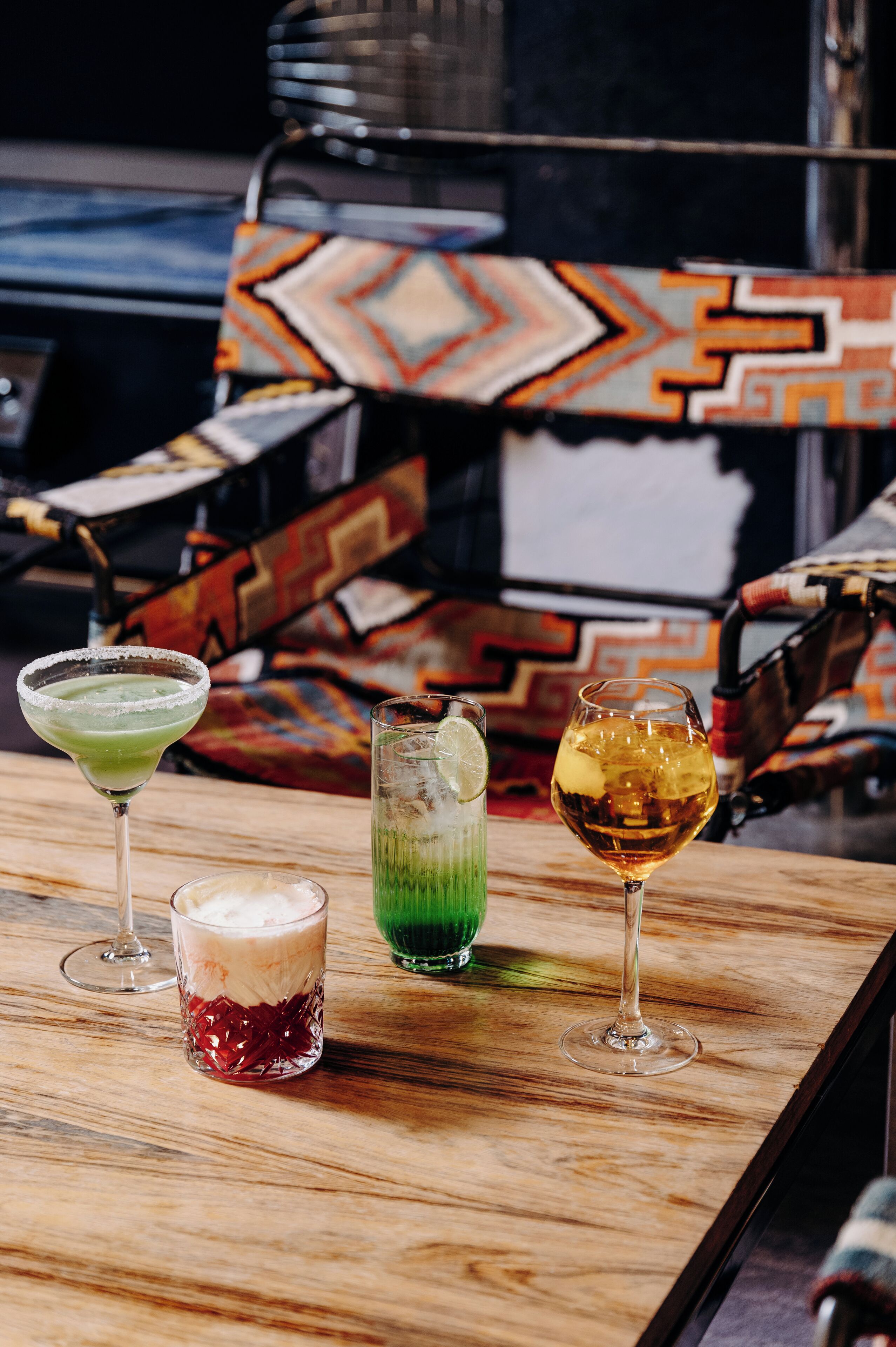 A bar area with three drinks on a wooden surface.