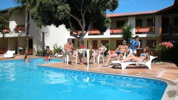 Una piscina al aire libre, sillones reclinables de piscina
