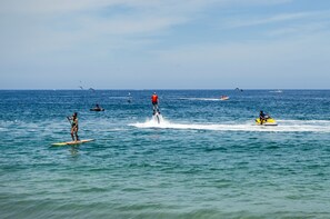A group of people on a calm sea, some on paddleboards and others on a jet ski. - Amapas Apartments Puerto Vallarta (Puerto Vallarta)
