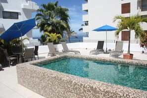 A rooftop pool with tiled edges, lounge chairs, and umbrellas. - Amapas Apartments Puerto Vallarta (Puerto Vallarta)