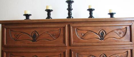 Une commode en bois avec quatre tiroirs et un plateau supérieur muni de cinq porte-bougies.