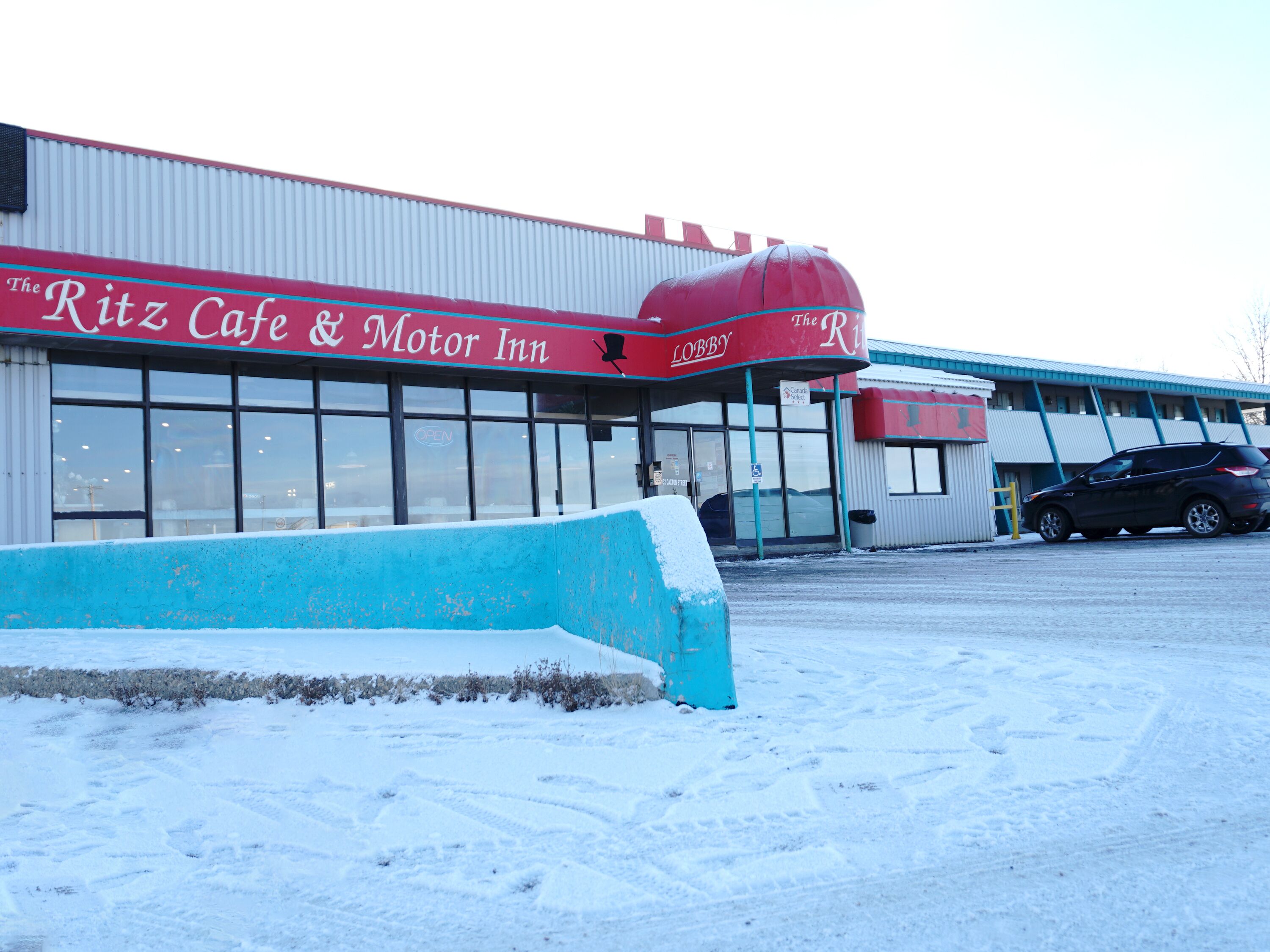 A building with a red awning labeled "The Ritz Cafe & Motor Inn."