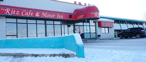 A building with a red awning labeled "The Ritz Cafe & Motor Inn."