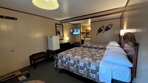 Una habitación de hotel con dos camas, televisión, escritorio y espejo.