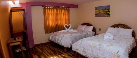 A hotel room with two beds, a mirror, a painting, and a wooden floor.