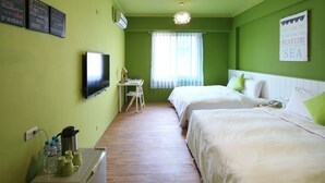 Une chambre d’hôtel avec deux lits, un bureau avec une chaise, une télévision et une fenêtre avec des rideaux.