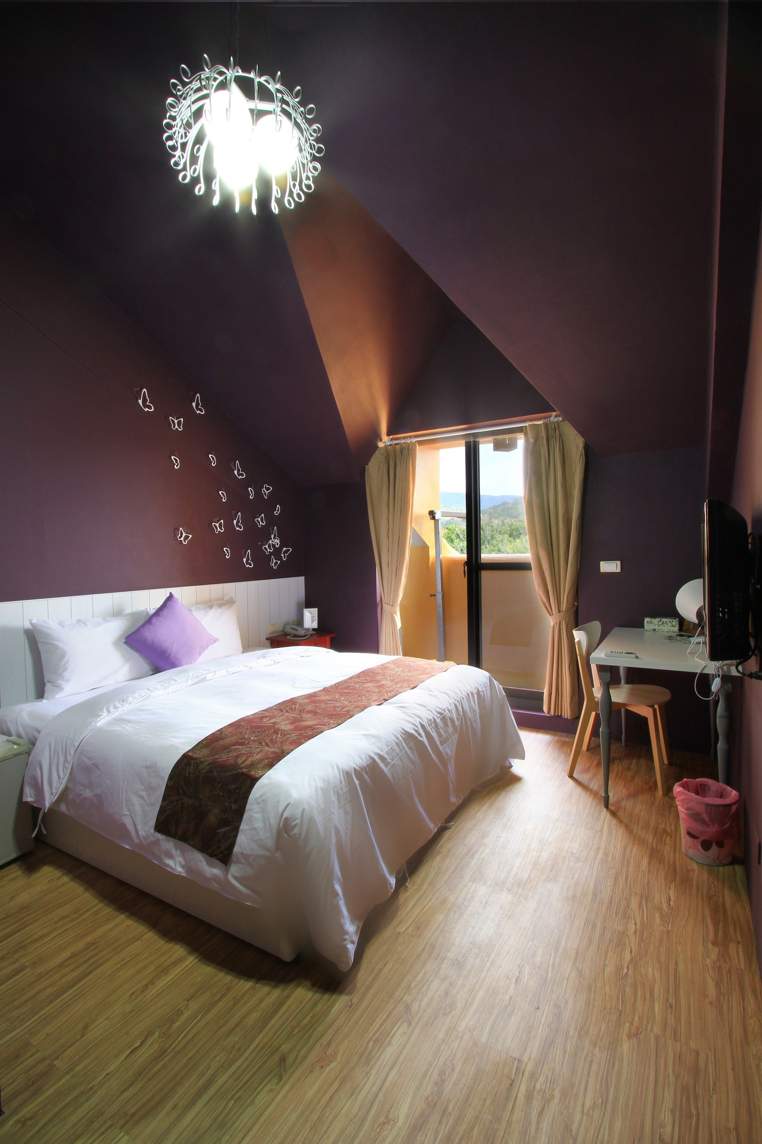 A bedroom with a bed, a desk, and a chair.