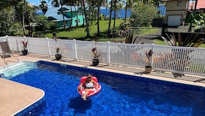 A swimming pool with a person in a red inflatable ring. - Ala Kai Bed & Breakfast (Keaau)