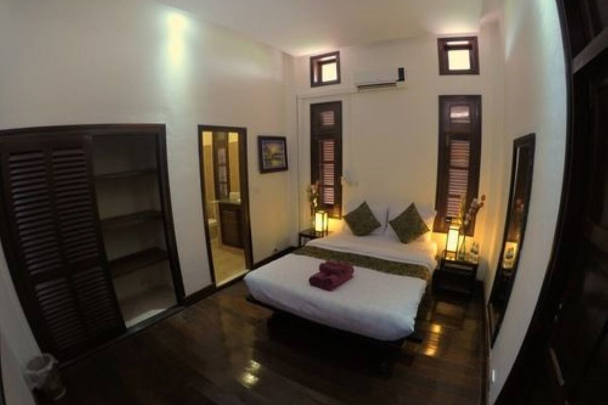 A bedroom with a bed, bedside tables, a wardrobe, and a mirror.