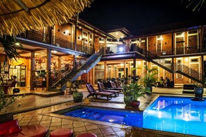 A hotel with a pool, outdoor seating, and multiple balconies. - Villa Vedici (Kampot)