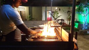 A person grilling food outdoors at night. - Nooit Gedacht Holiday Resort (Unawatuna)