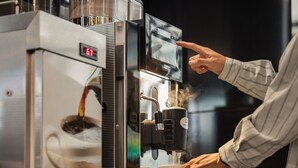 A coffee machine with a digital display and a touchscreen interface.