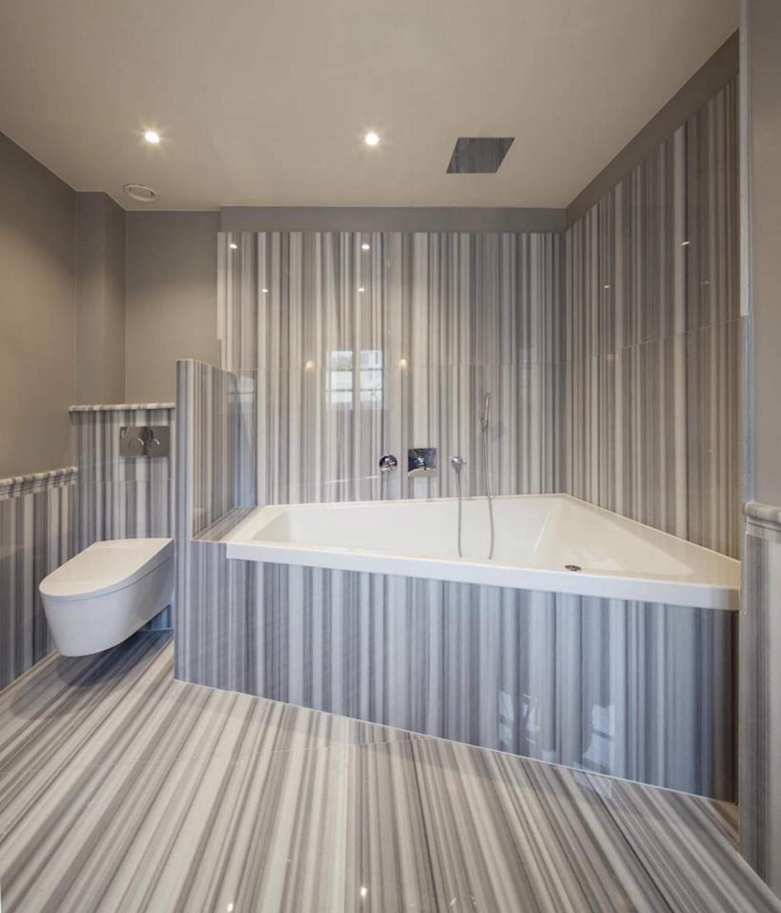 Un baño moderno con una bañera independiente, un inodoro y una zona de ducha.
